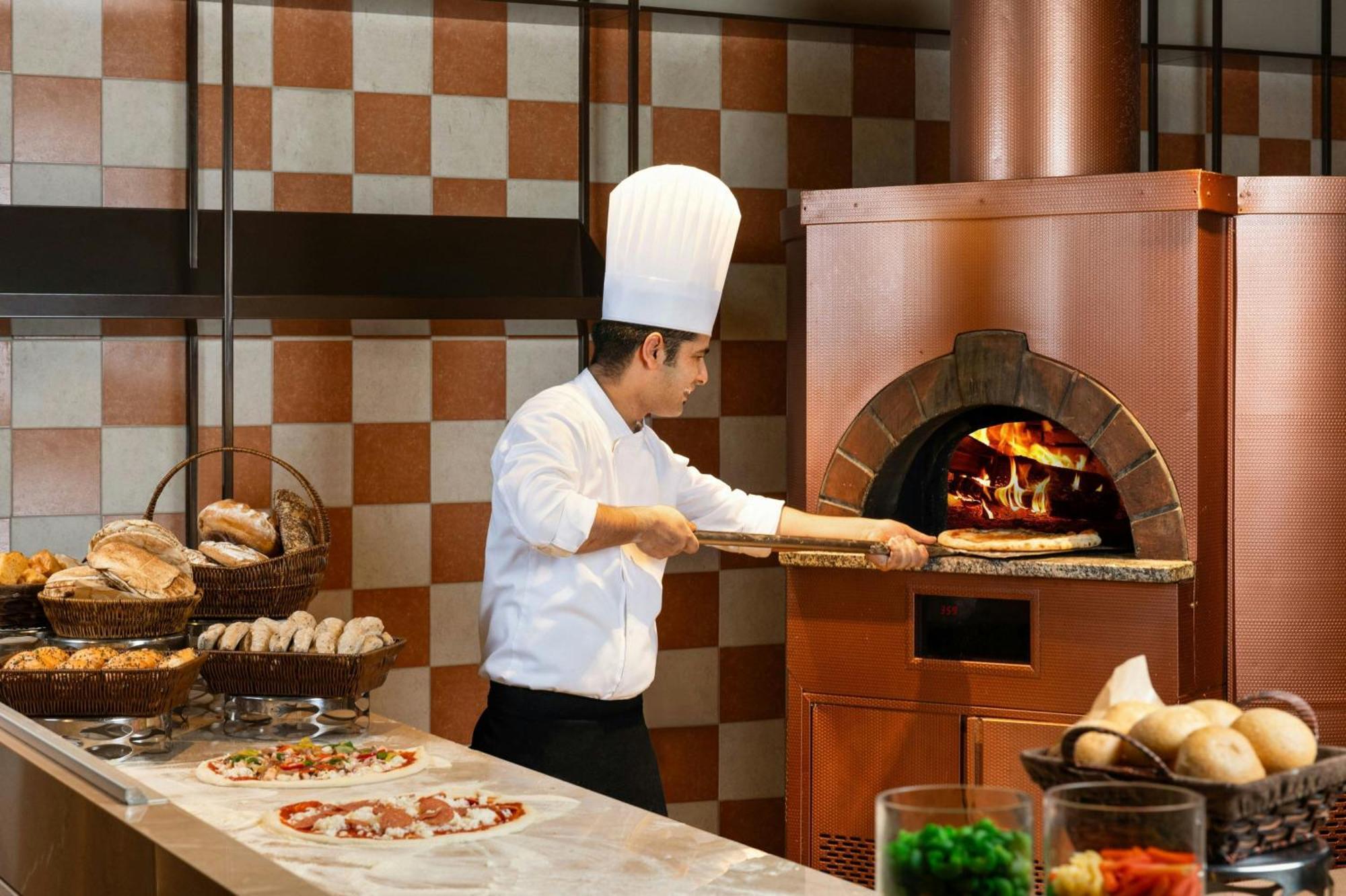 Ajman Saray, A Luxury Collection Resort, Ajmán Exterior foto A pizzaiolo making a pizza